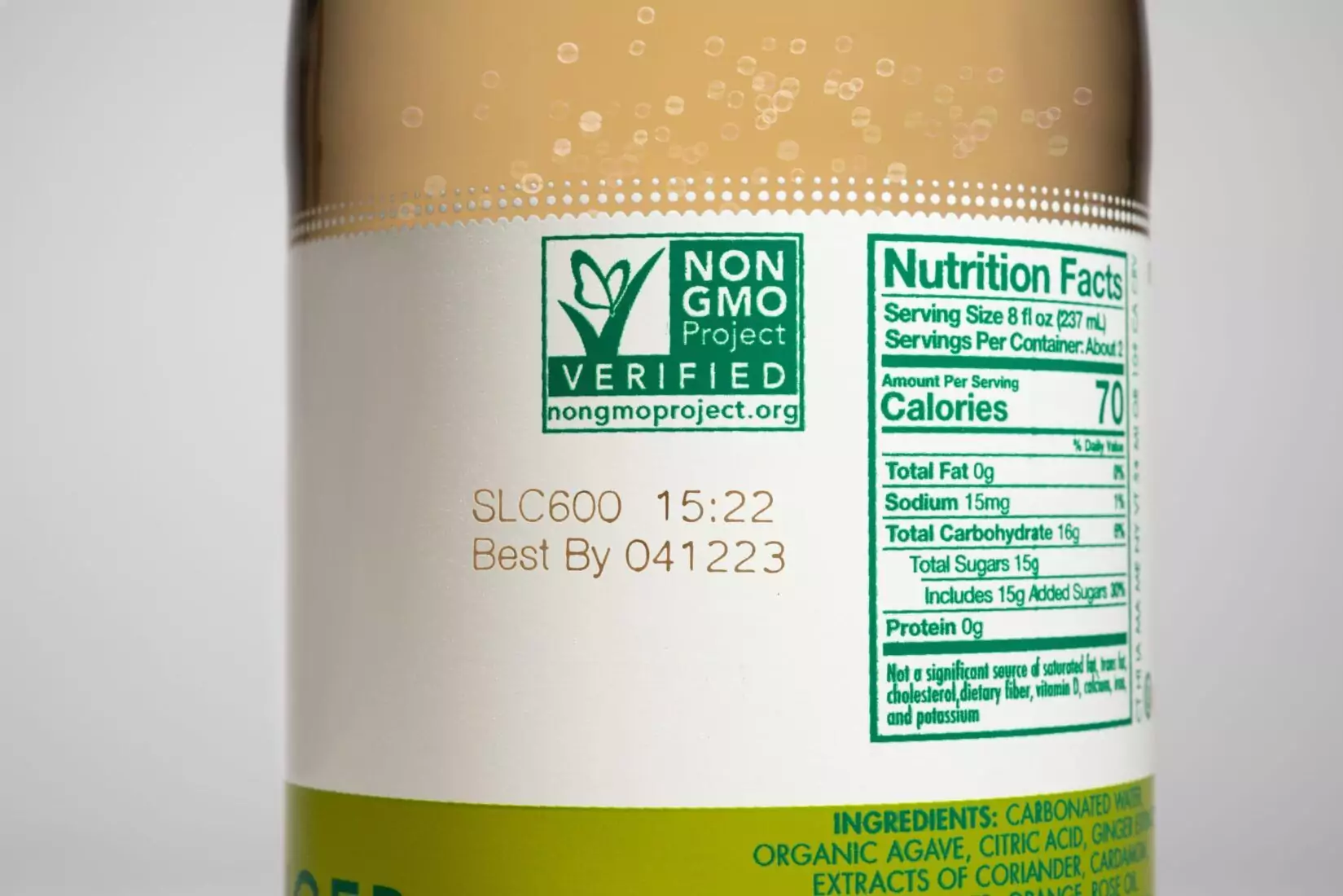 Close-up of a label applicator machine applying labels to packaged products on a conveyor belt.